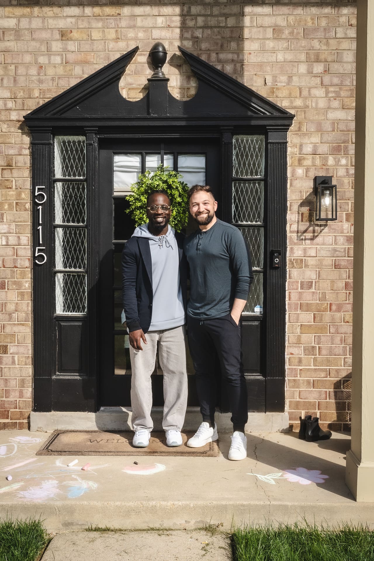 Hassan and his agent outside his new home